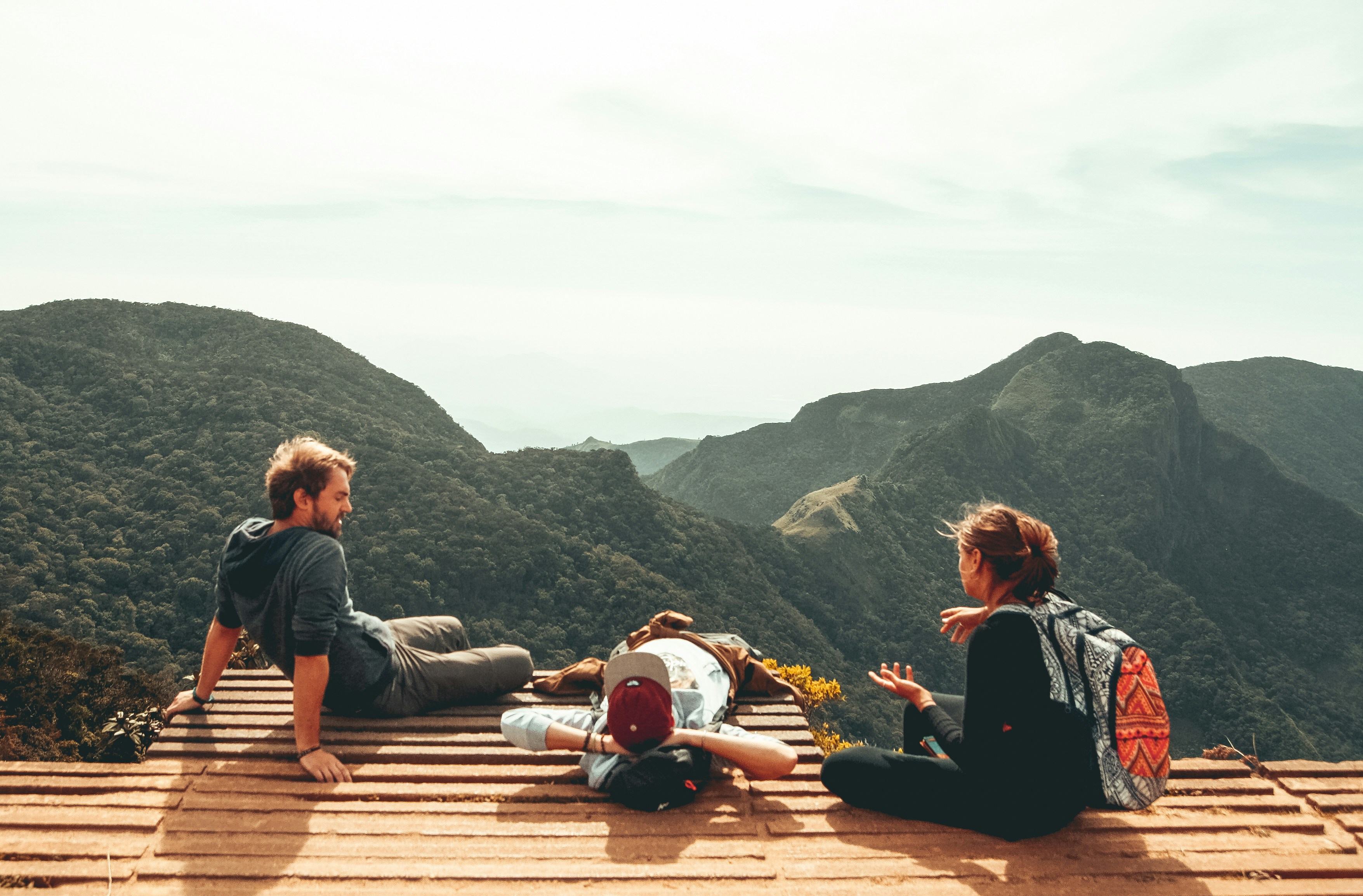 Travelers sitting on steps overlooking mountains
