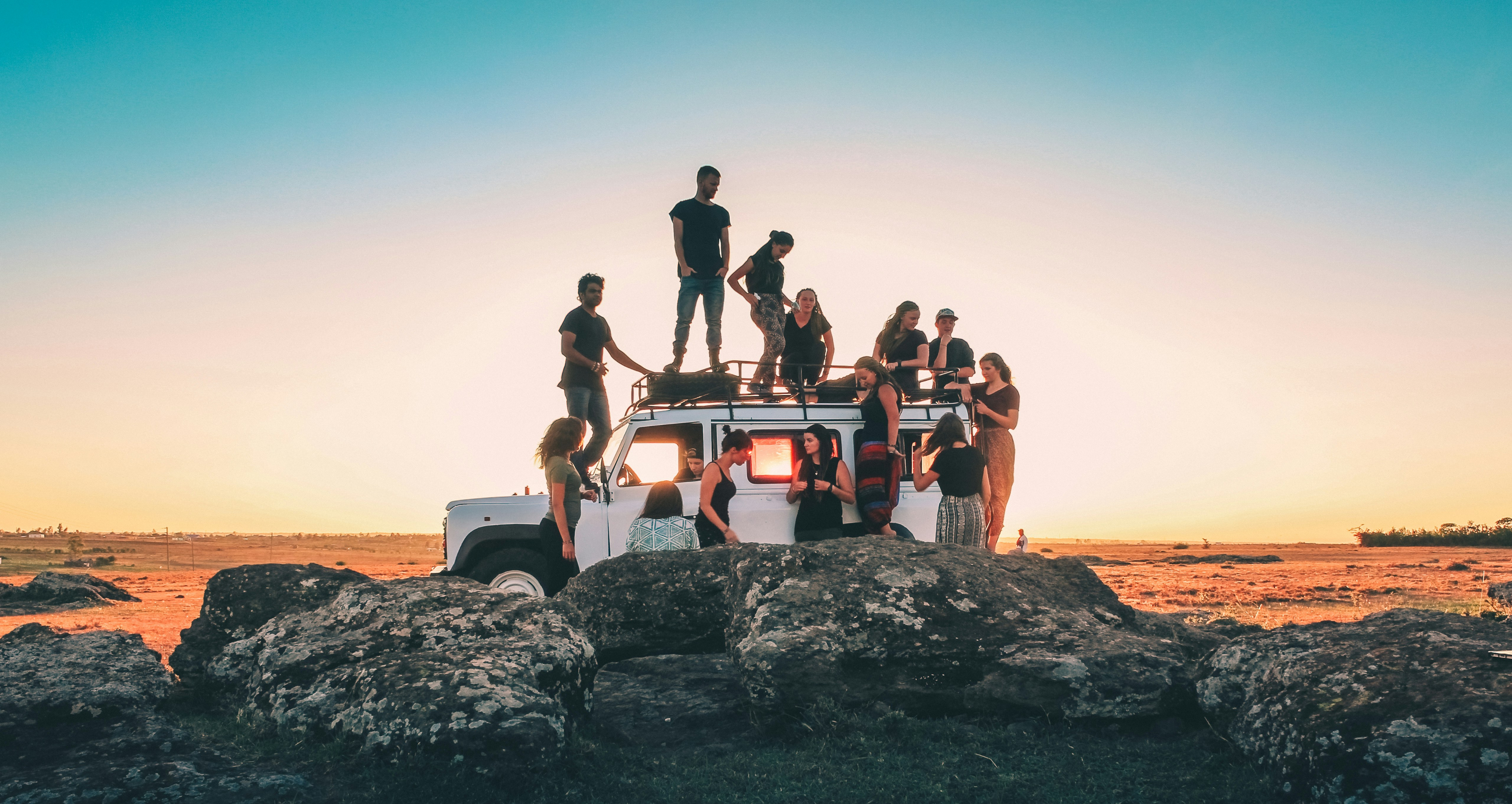 Group of travelers on a jeep at sunset